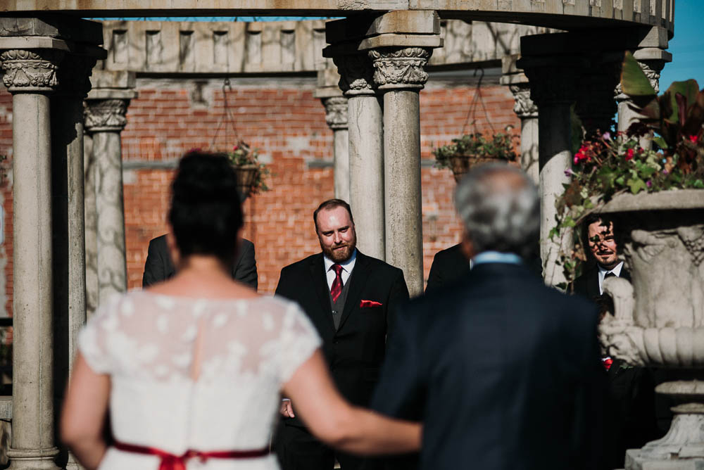 groom looking at bride and father
