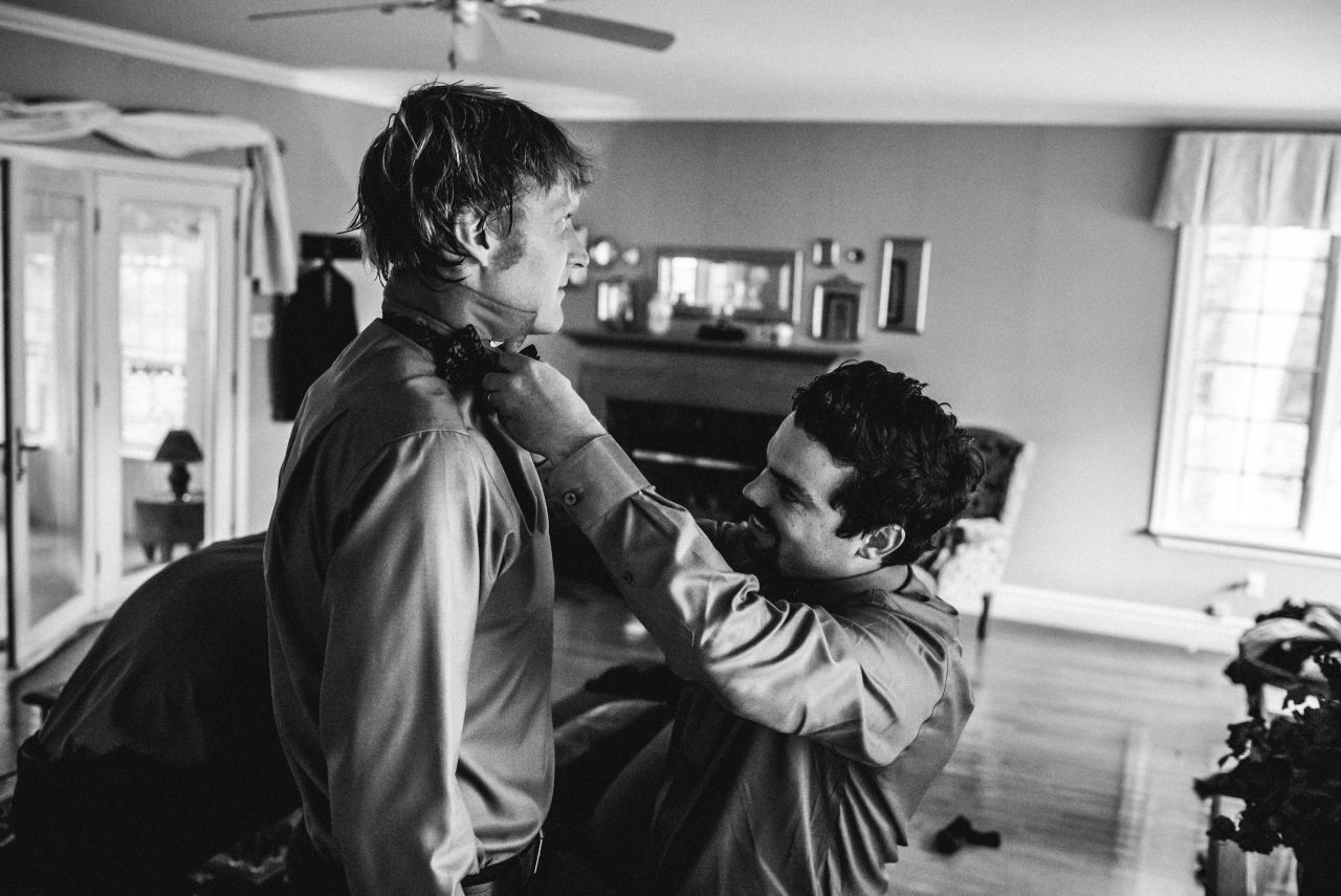 groomsman adjusting tie of fellow groomsman
