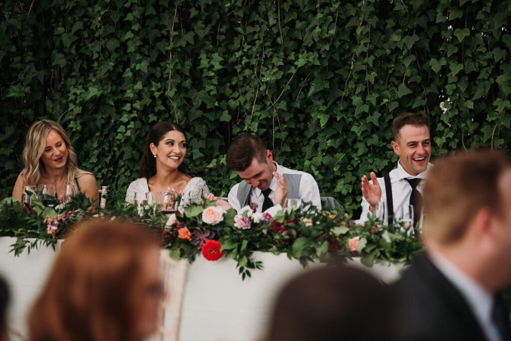 bridal party laughing during speeches at aquatopia wedding