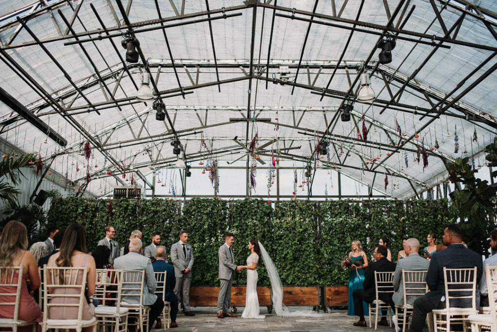 bride and groom holding hands during ceremony for their wedding at aquatopia