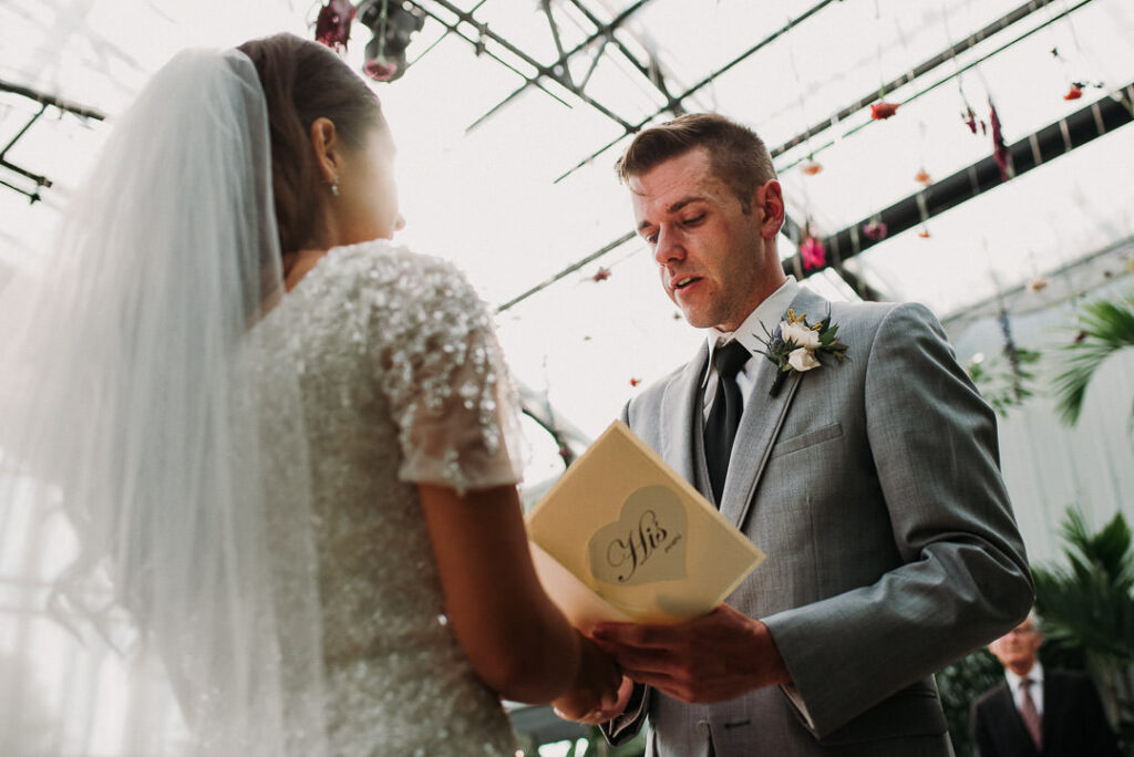 bride and groom reading vows during wedding ceremony at aquatopia