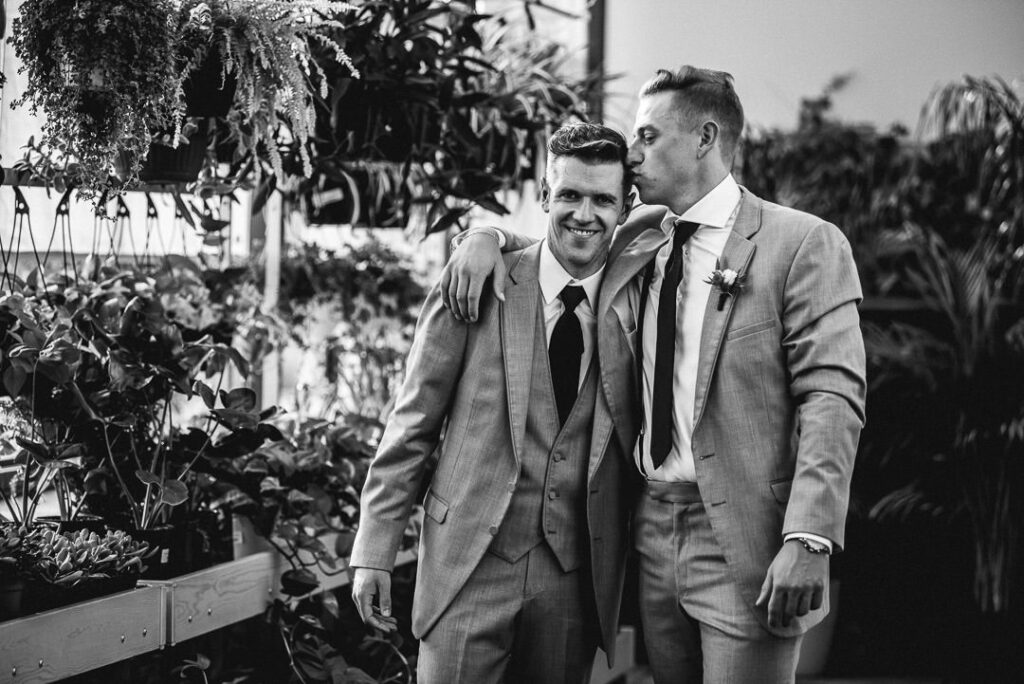 brother kisses grooms forehead before wedding ceremony at aquatopia