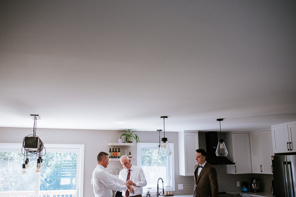 groom getting ready for his rustic wedding at tucker house
