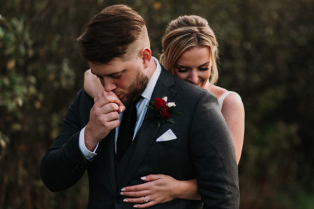 groom kissing brides hand at Aquatopia wedding