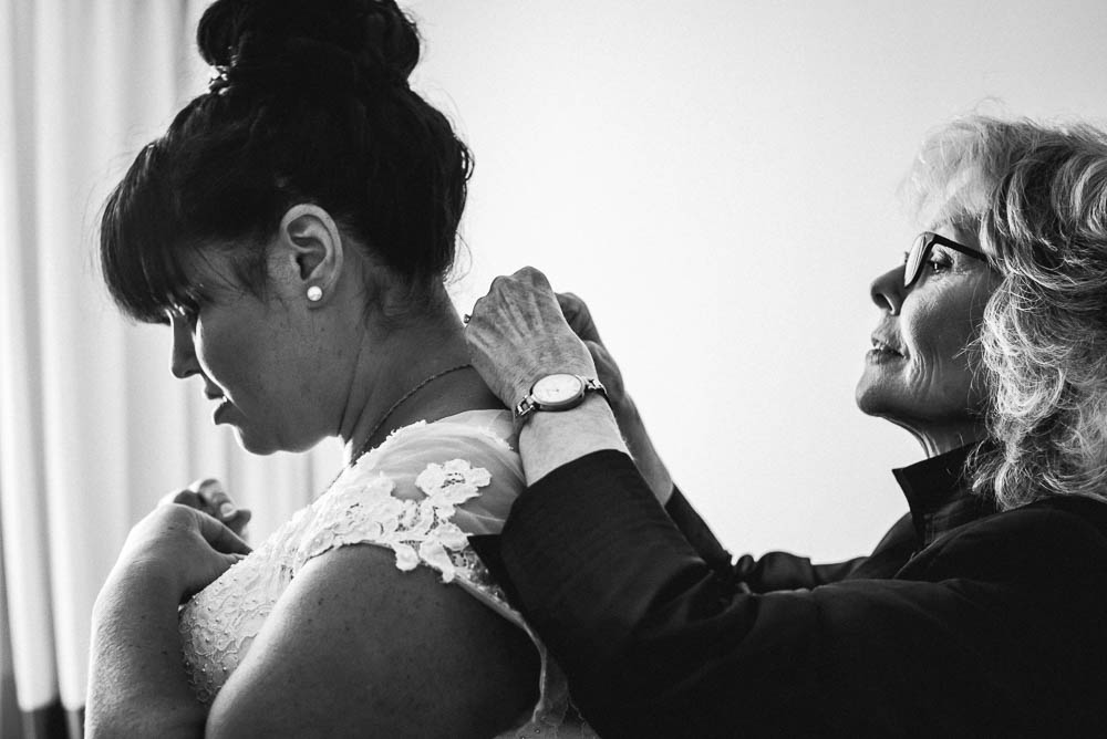 mother of bride putting on brides necklace