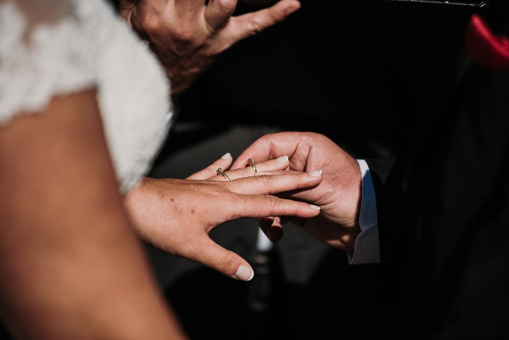 groom putting ring on bride's finger