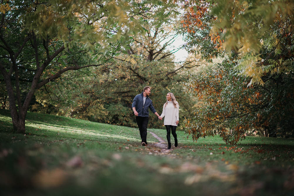 photo of couple walking hand in hand down path