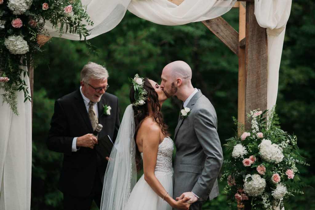 bride and groom first kiss during their backyard wedding