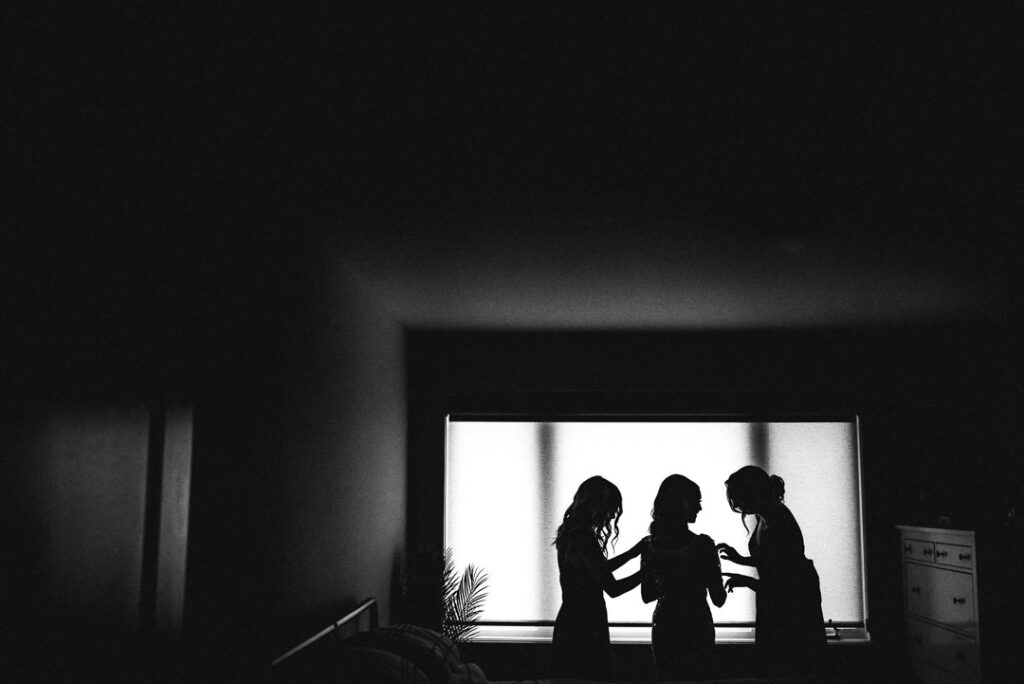 black and white silhouette of bride getting ready with bridesmaids