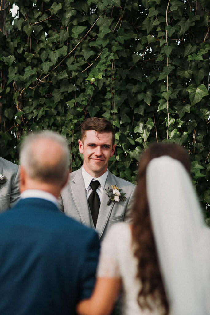 groom watching bride walk down aisle during aquatopia wedding