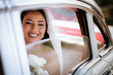 bride smiling in car on way to wedding at notre dame basilica