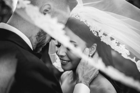 bride and groom portrait with veil over their heads